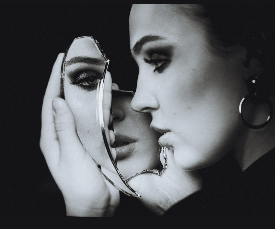 A young girl looks at herself in a fragmented mirror